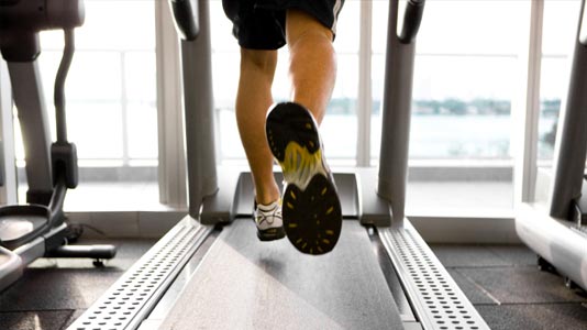 The legs of a man running on a treadmill